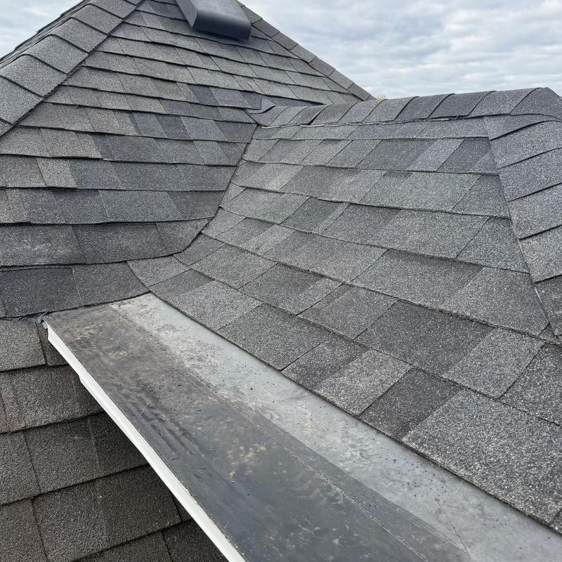 Asphalt shingle roof with repaired valley and flashing