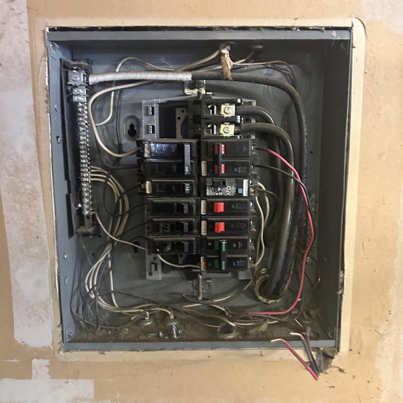 Electrical breaker panel with wiring in unfinished wall