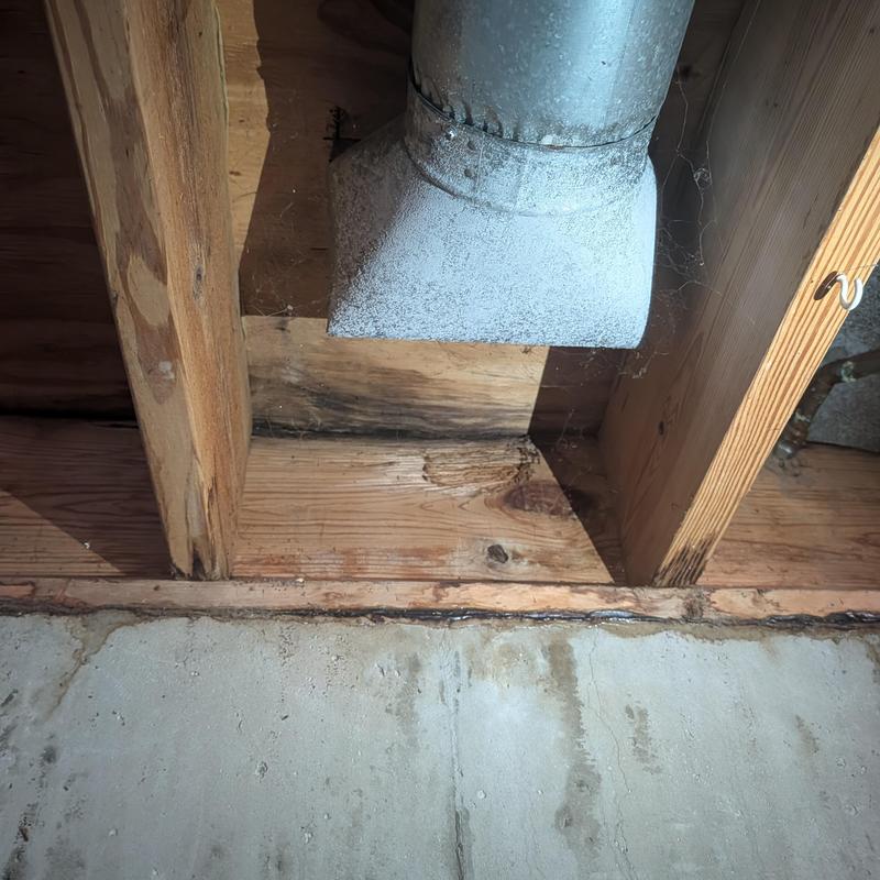 Basement wall wood frame with water damage and vent duct