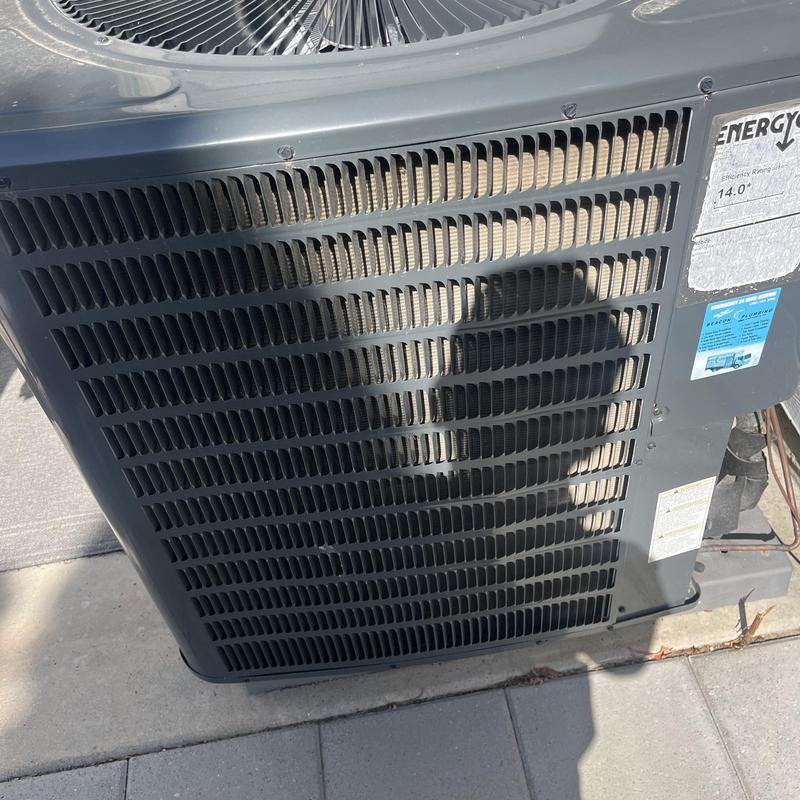 Air conditioner condenser unit with visible coils and fan Air conditioner condenser unit with visible coils and fan