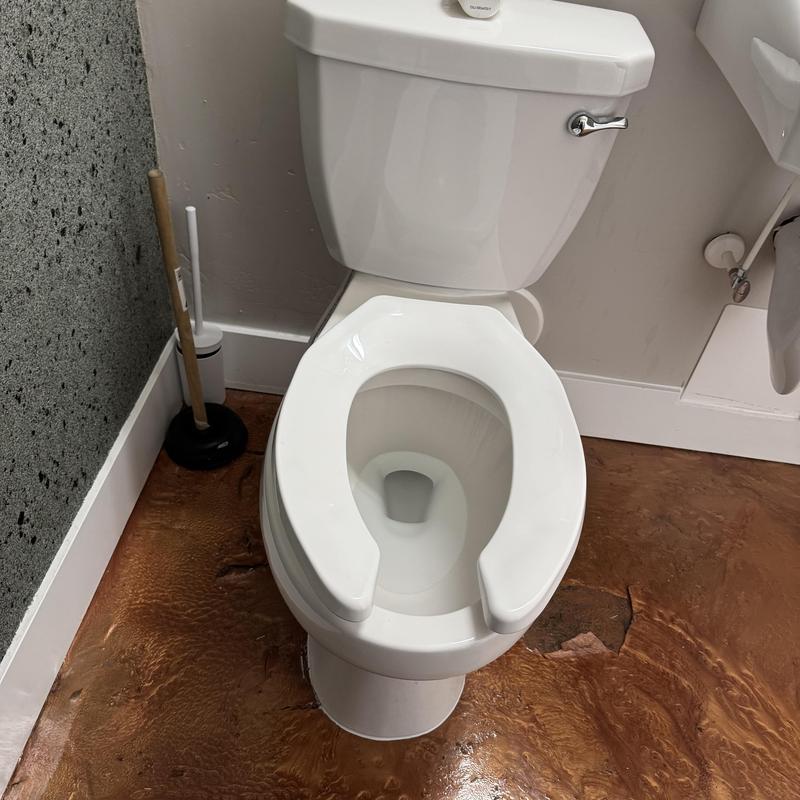 Commercial toilet with plunger in restroom corner Commercial toilet with plunger in restroom corner
