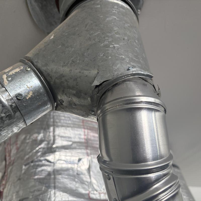 Deteriorated HVAC furnace flue fitting with cracking Deteriorated HVAC furnace flue fitting with cracking