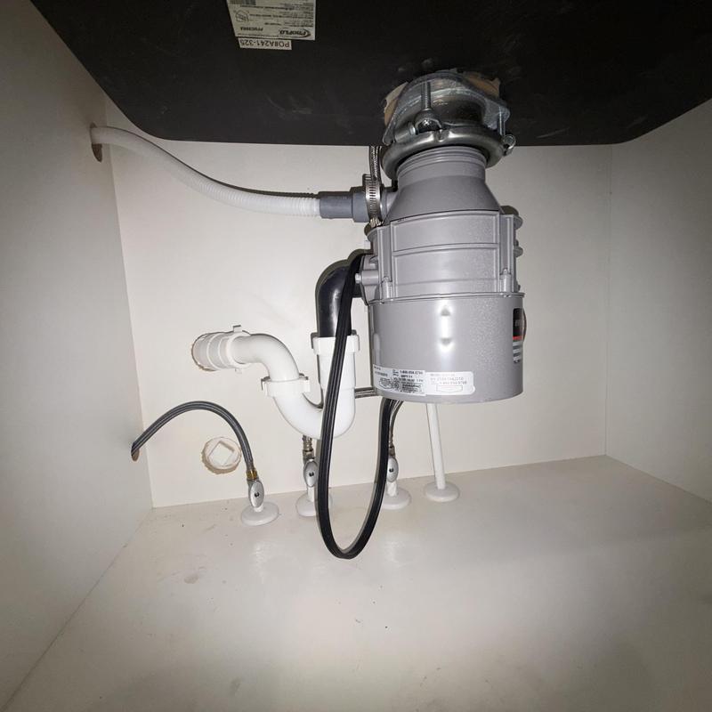 Garbage disposal and drain pipes under sink, clean setup Garbage disposal and drain pipes under sink, clean setup
