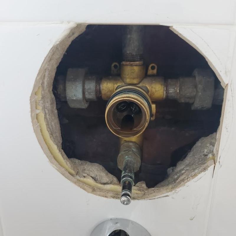 Shower valve body exposed through wall access hole Shower valve body exposed through wall access hole
