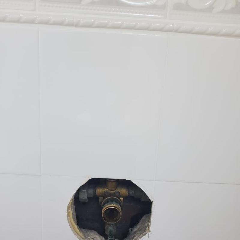 Shower valve plumbing access hole with exposed valve Shower valve plumbing access hole with exposed valve