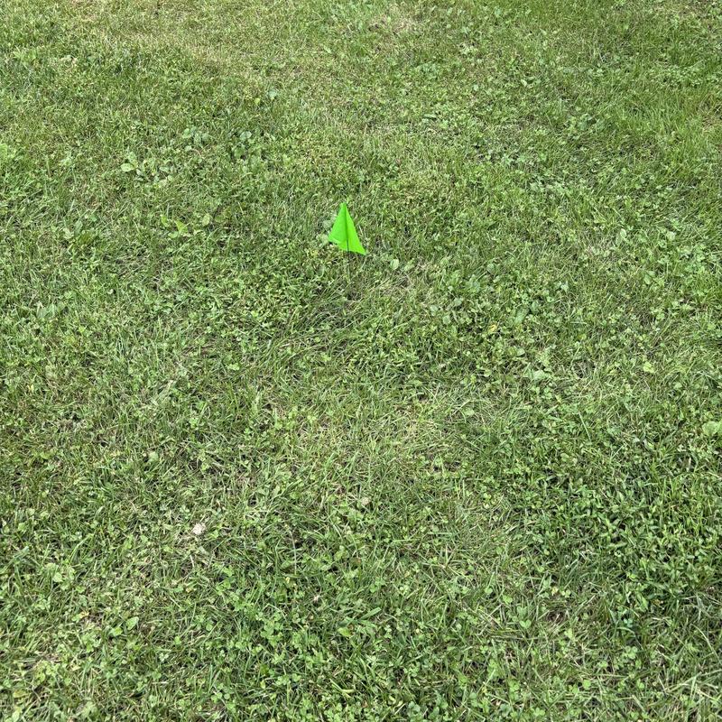 Underground utility line marked with green flag on grass Underground utility line marked with green flag on grass