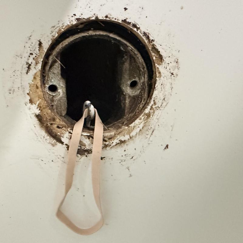Bathroom vent pipe opening with hanging rubber strap Bathroom vent pipe opening with hanging rubber strap