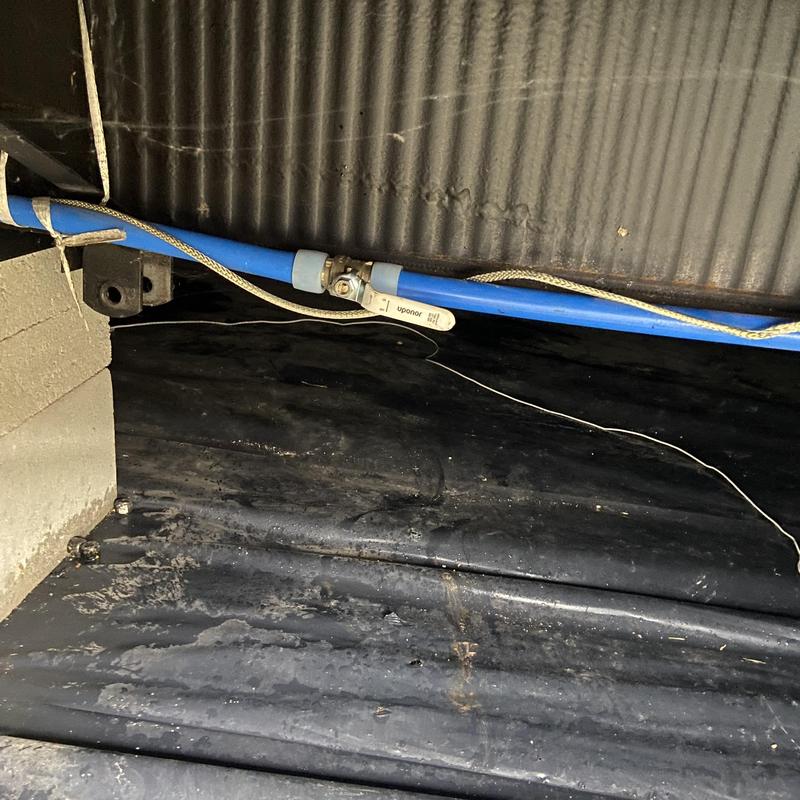 Main water shutoff valve with blue piping beneath floor