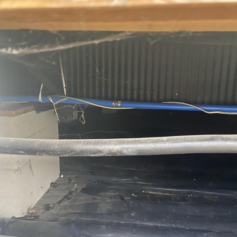 Laundry room PEX water line under floor with clamps