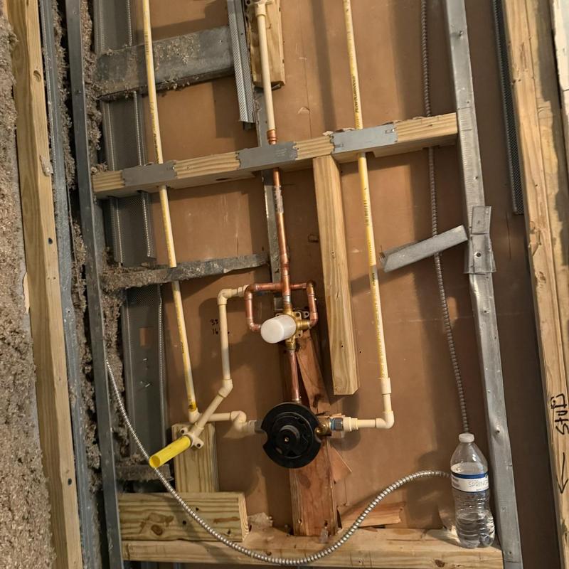 Shower valve rough-in with plumbing pipes in wall framing