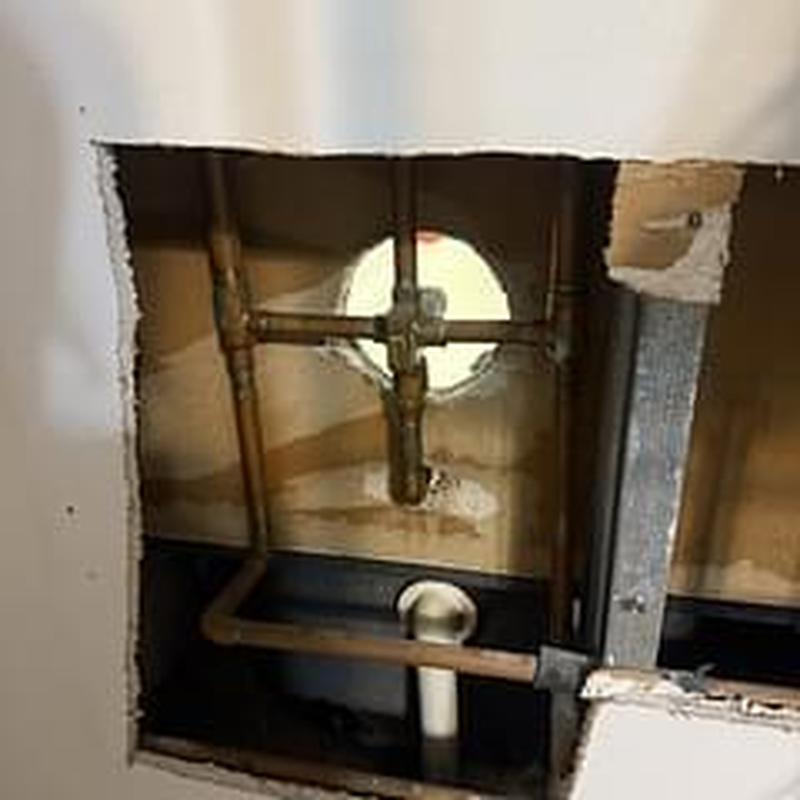 Shower valve and plumbing pipes behind wall cavity