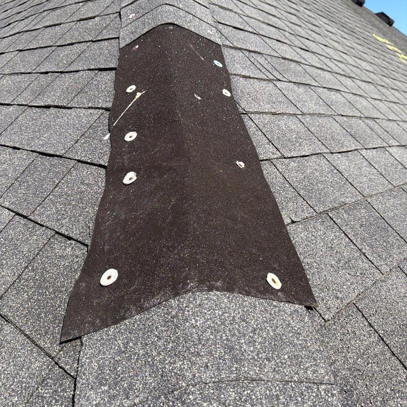 Roof ridge flashing with hail damage on shingles