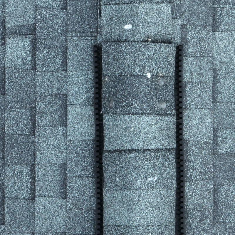 Asphalt roof shingles with hail damage impacts