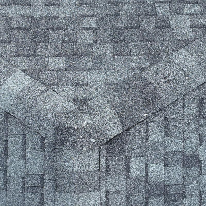 Asphalt shingle vent with hail damage and granule loss