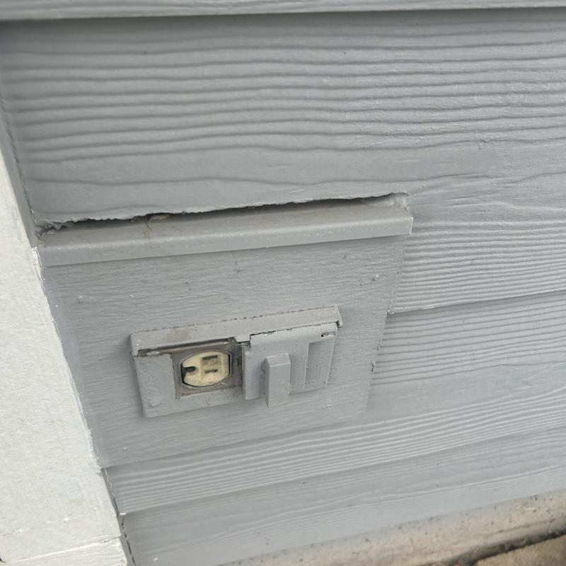 Exterior electrical receptacle with protective cover on siding
