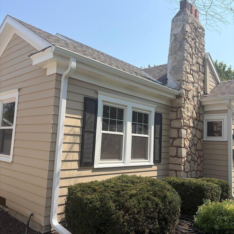 White aluminum gutters installed on beige house exterior White aluminum gutters installed on beige house exterior