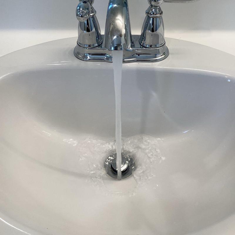 Pop-up drain assembly with flowing water in sink