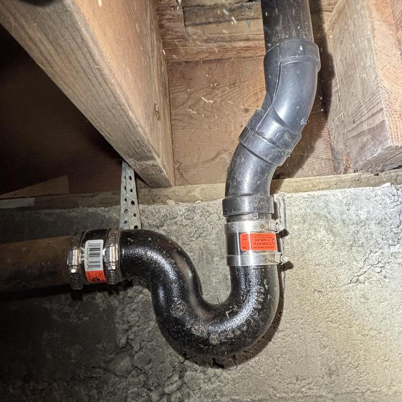 Cast-iron P-trap with mechanical bands under building Cast-iron P-trap with mechanical bands under building