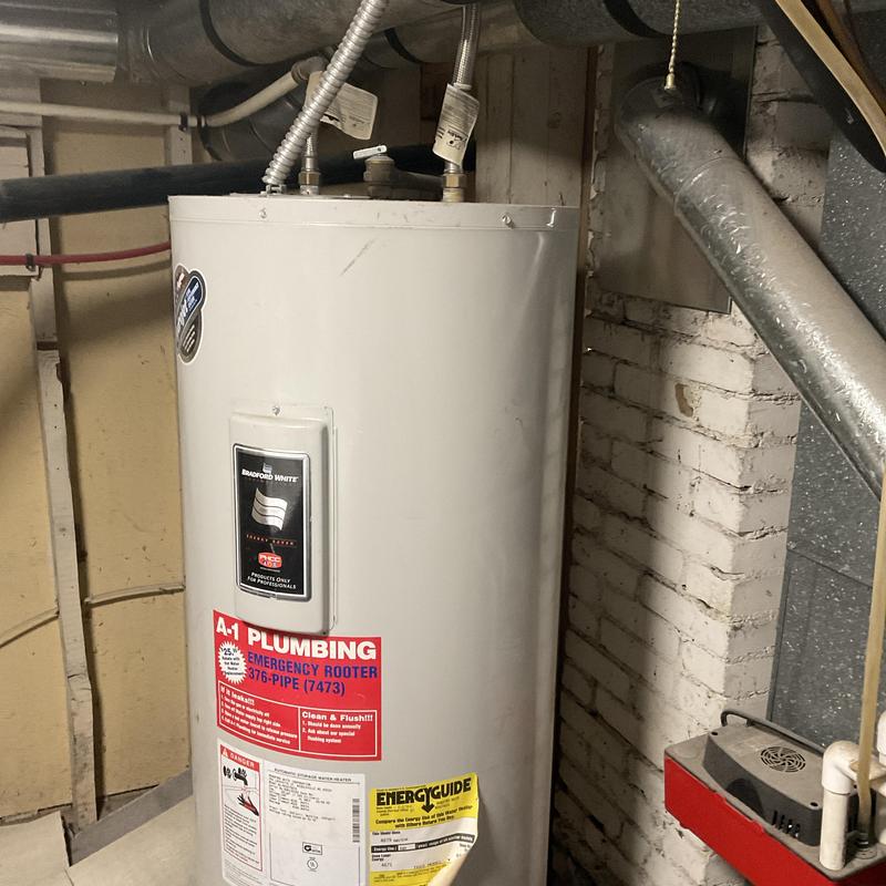 Water heater with plumbing connections in basement