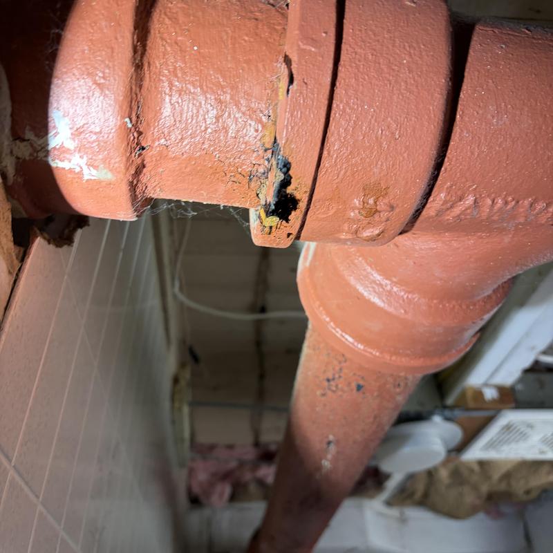 Cast-iron drain pipe with hole and corrosion damage