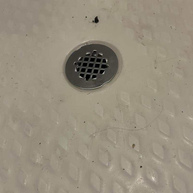 Shower drain with new chrome drain cover on textured floor Shower drain with new chrome drain cover on textured floor