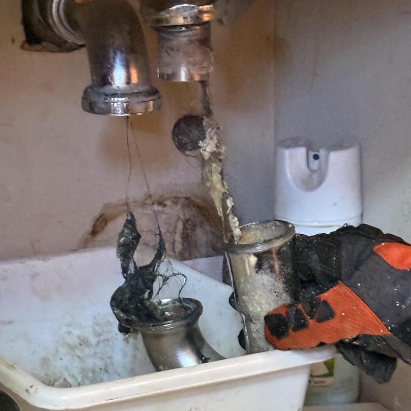 Laundry sink drain pipes with clog removal in progress Laundry sink drain pipes with clog removal in progress