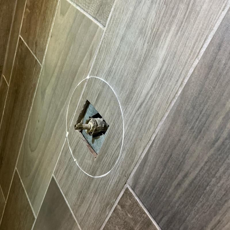 Faucet cartridge valve exposed for replacement in tile wall