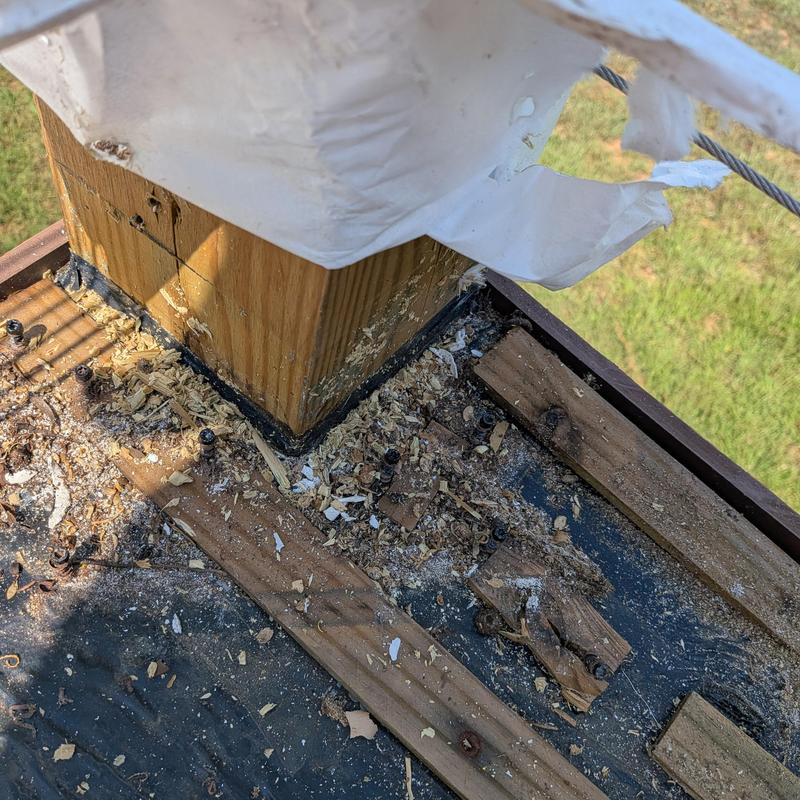 Deck post base with wood damage and debris Deck post base with wood damage and debris