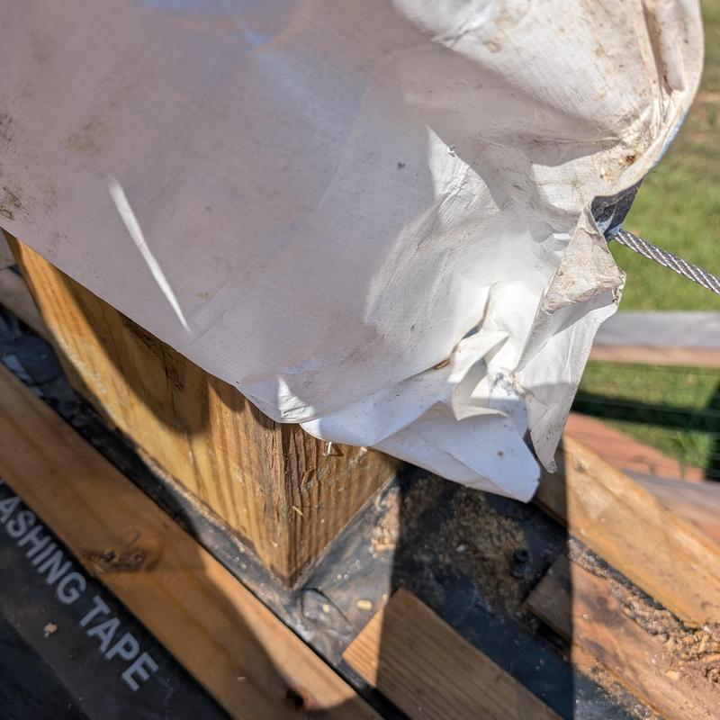 Deck post with protective tarp and flashing tape edges Deck post with protective tarp and flashing tape edges