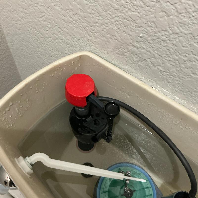 Toilet fill valve and float assembly inside tank