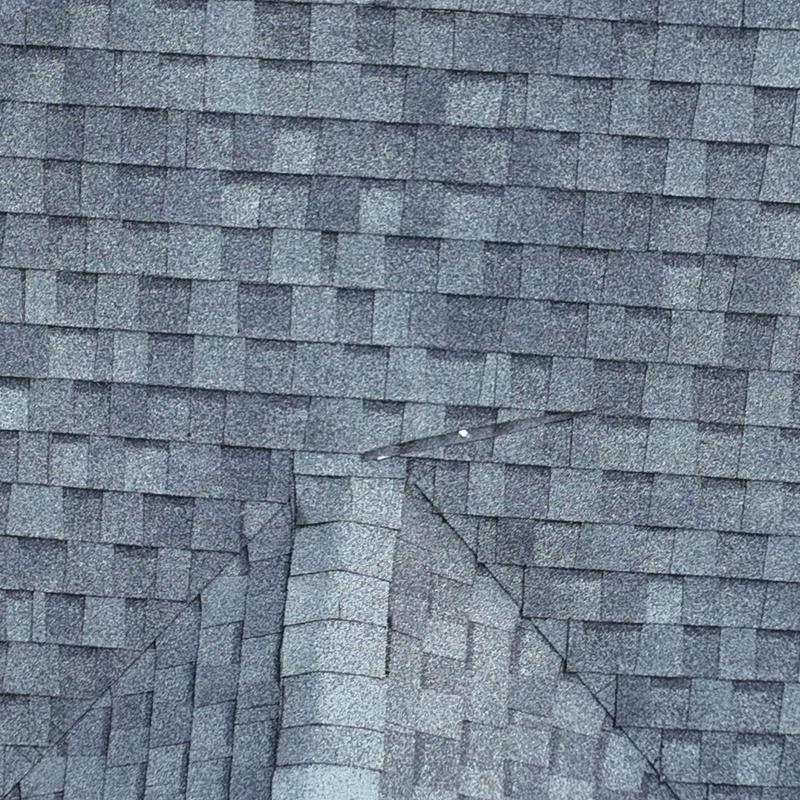 Asphalt shingle roof with hail damage on ridge area