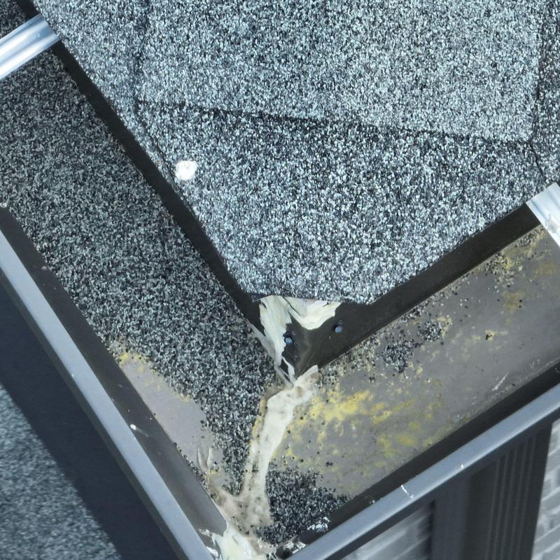 Roof shingle corner with hail damage and sealant repairs
