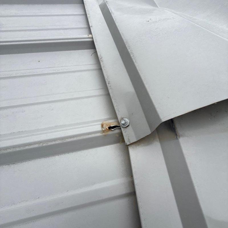 Metal roof panel with puncture hole near seam bolt