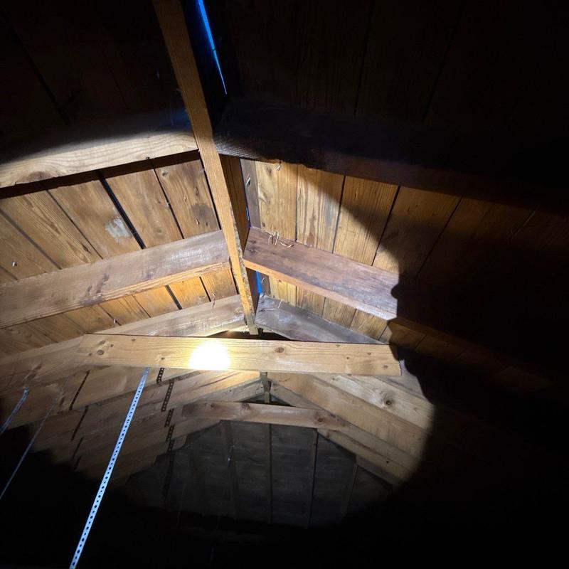 Wooden roof trusses under inspection with flashlight light
