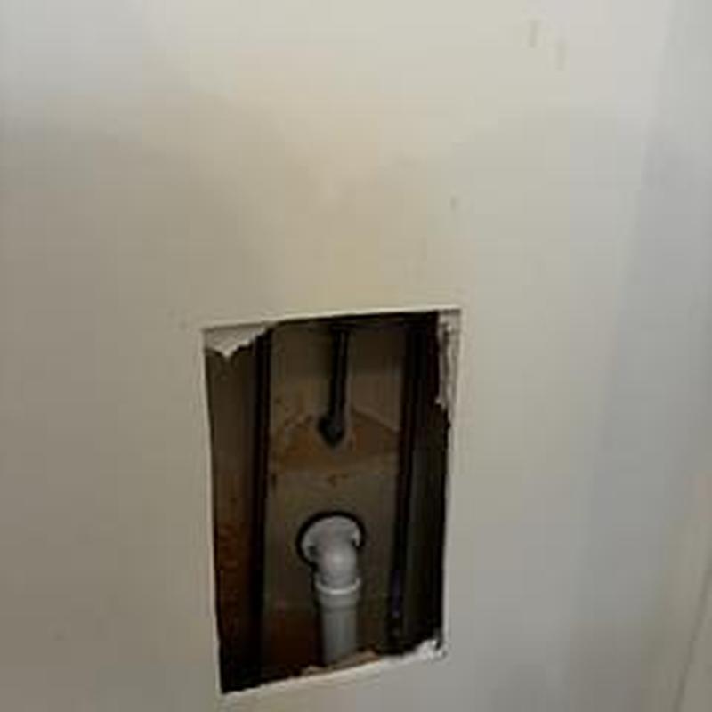 PVC drain pipe inside drywall access hole for leak detection
