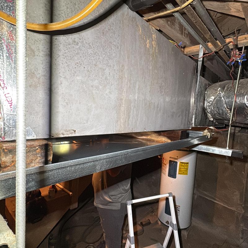 Drain pan under HVAC ductwork in basement space