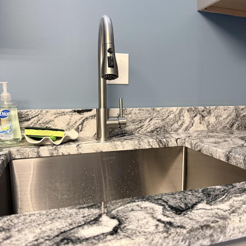 Kitchen faucet with spray nozzle on granite countertop Kitchen faucet with spray nozzle on granite countertop