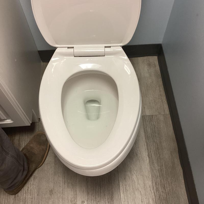 Toilet bowl with open lid on bathroom floor Toilet bowl with open lid on bathroom floor