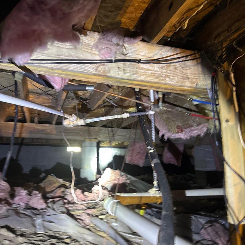 Piping and insulation in crawl space with exposed wiring