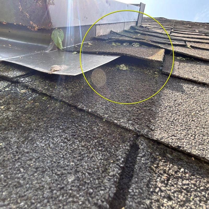 Asphalt shingles with hail damage near flashing