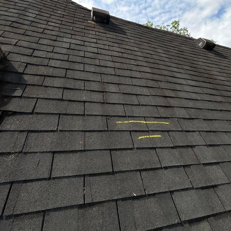 Roof shingles with hail damage marked in yellow chalk
