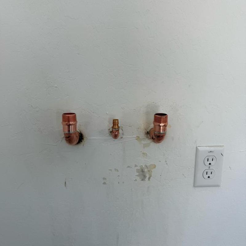 Copper water supply pipe fittings installed in wall next to outlet