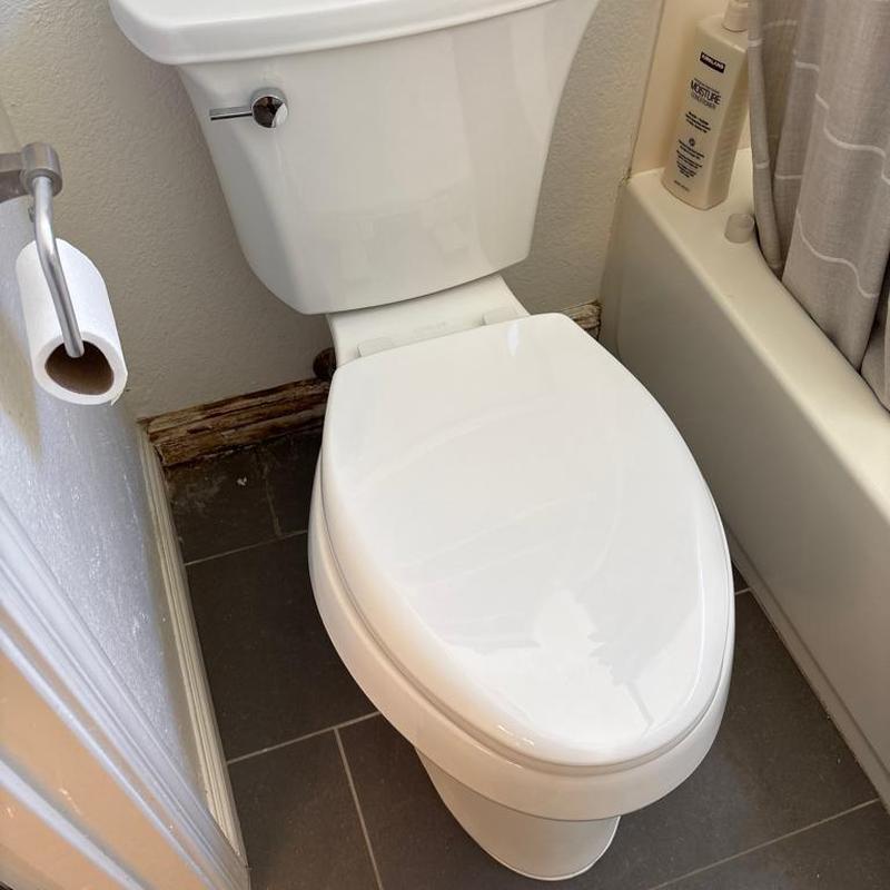 Toilet with closed lid in bathroom corner
