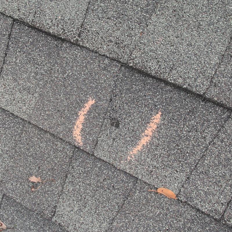 Roof shingle hail damage marked with chalk