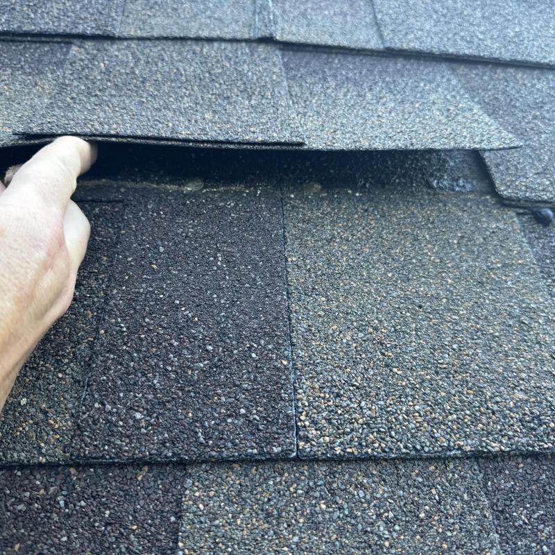 Roof shingles lifted to check adhesion and condition