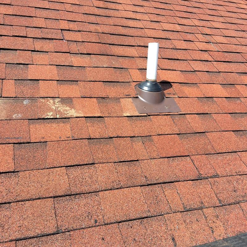 Roof vent collar on red shingle roof with repairs Roof vent collar on red shingle roof with repairs
