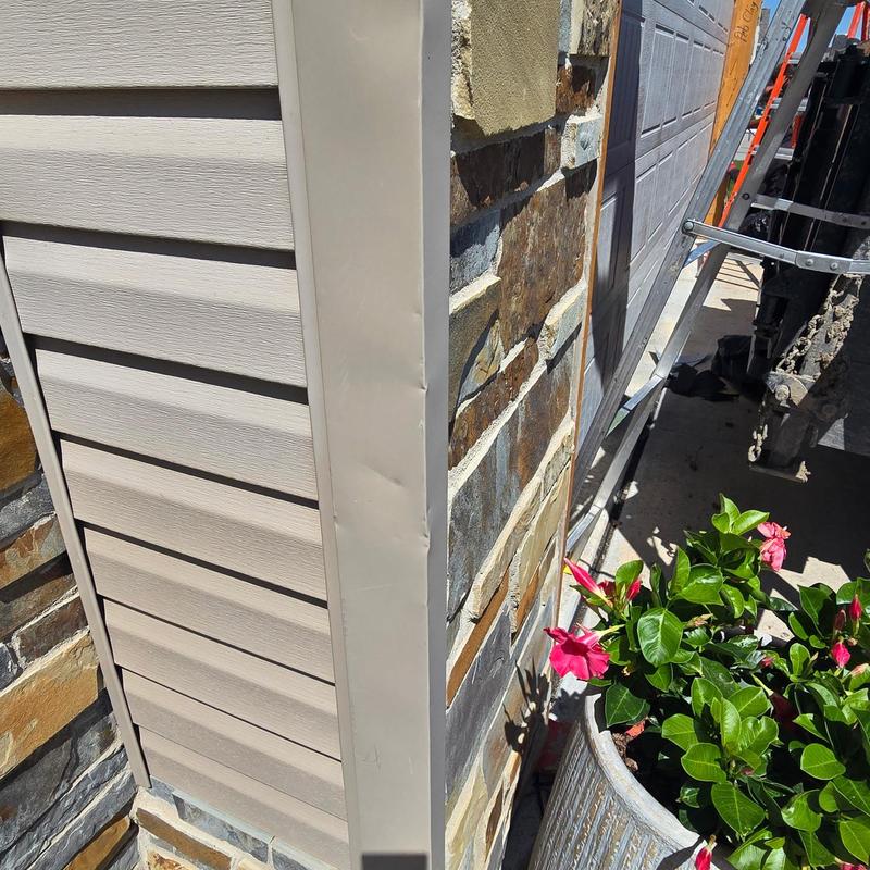Vinyl siding corner installation with stone veneer background Vinyl siding corner installation with stone veneer background