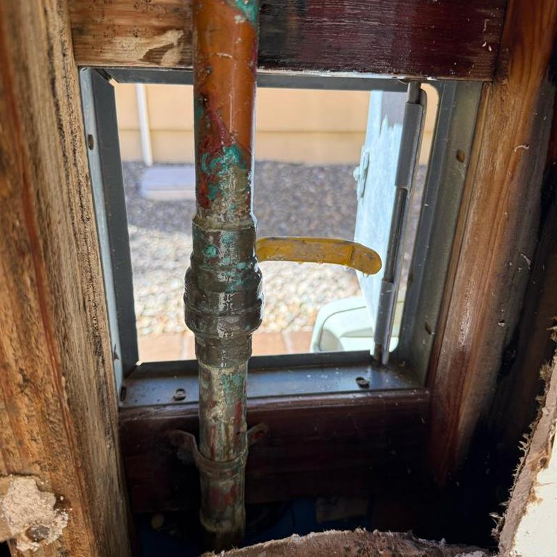 Copper ball valve with yellow handle in wall cavity
