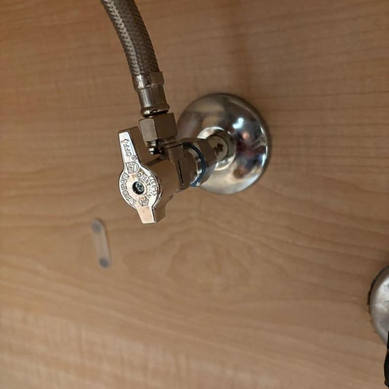 Angle stop valve with supply line installed on wood panel
