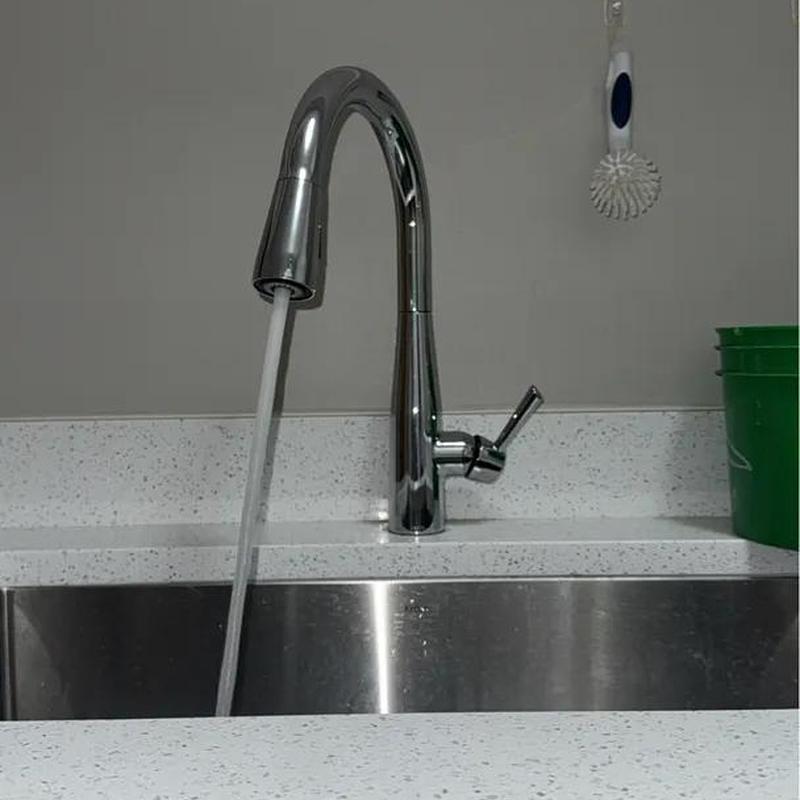Laundry room faucet with running water on countertop